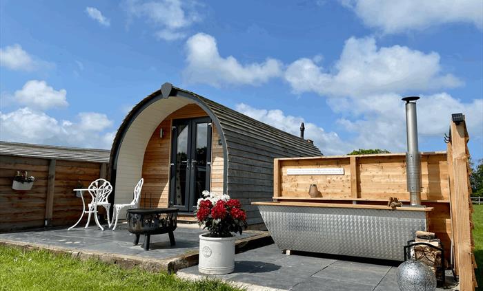 Outside luxury glamping pod with wood fired hot tub